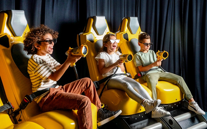 Children enjoying a virtual reality ride at Play DXB with interactive controls.