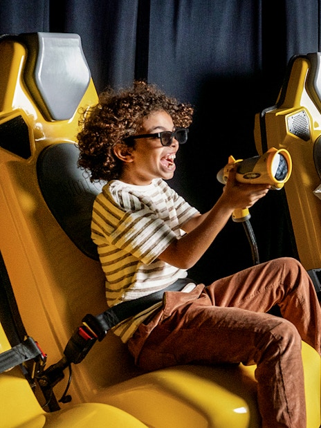 Children enjoying a virtual reality ride at Play DXB with interactive controls.