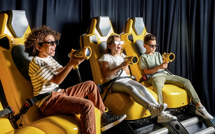 Children enjoying a virtual reality ride at Play DXB with interactive controls.