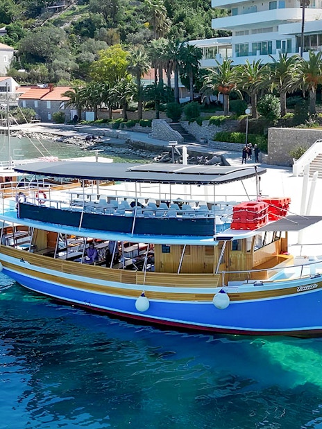 Boat docked along the shores of Elaphiti Islands with coastal buildings in the background.