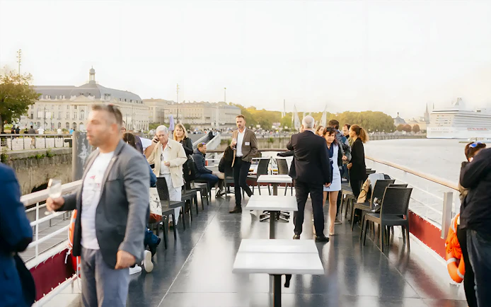 People enjoying wine tasting on a Bordeaux River Cruise deck.