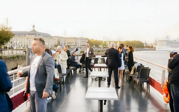People enjoying wine tasting on a Bordeaux River Cruise deck.