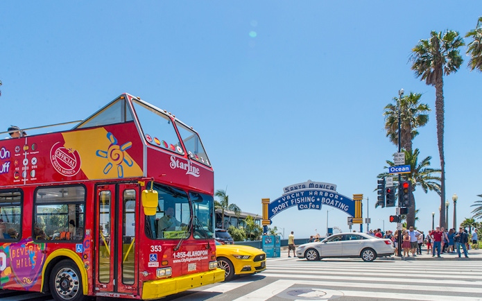 Open-top tour bus near Santa Monica Pier entrance, Los Angeles.
