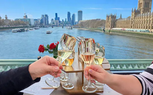 Cheers with sparkling wine on a London bus tour, overlooking the Thames and city skyline.
