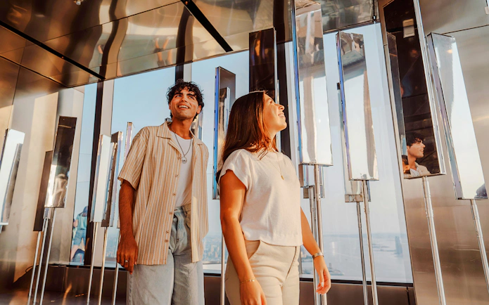 Visitors exploring the mirrored walls at Edge NYC Observation Deck.