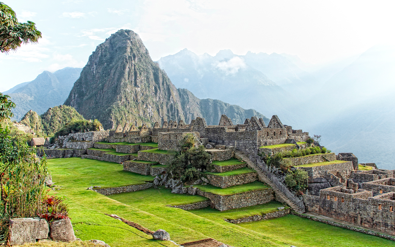Machu Picchu ruins with mountain backdrop from lower terrace viewpoint.