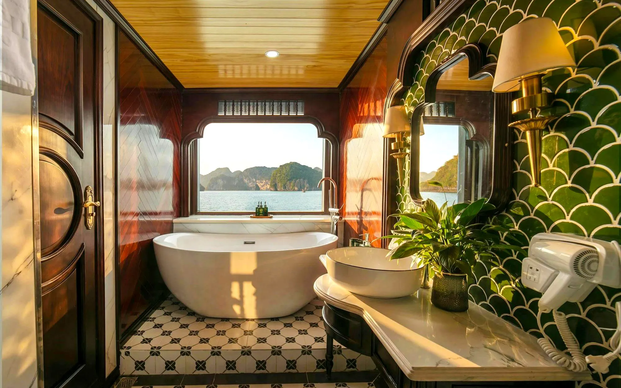 Luxurious bathroom with a bathtub and sea view on Du Junior Cabin, Ha Long Bay cruise.