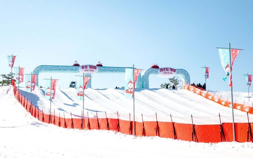 Snow tubing lanes at Vivaldi Park Ski World, South Korea, with colorful banners.