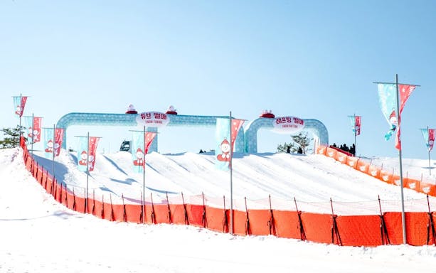 Snow tubing lanes at Vivaldi Park Ski World, South Korea, with colorful banners.