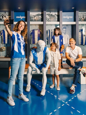 Visitors taking a selfie with a statue at FC Porto Museum, Porto, Portugal.