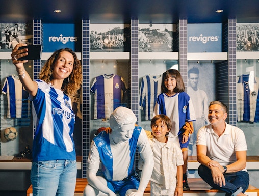 Visitors taking a selfie with a statue at FC Porto Museum, Porto, Portugal.