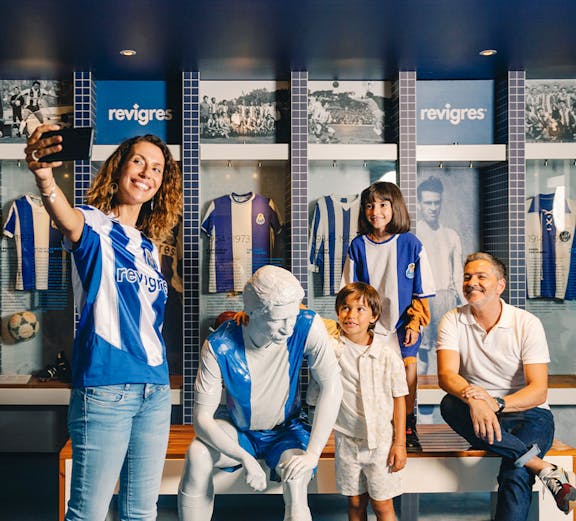 Visitors taking a selfie with a statue at FC Porto Museum, Porto, Portugal.