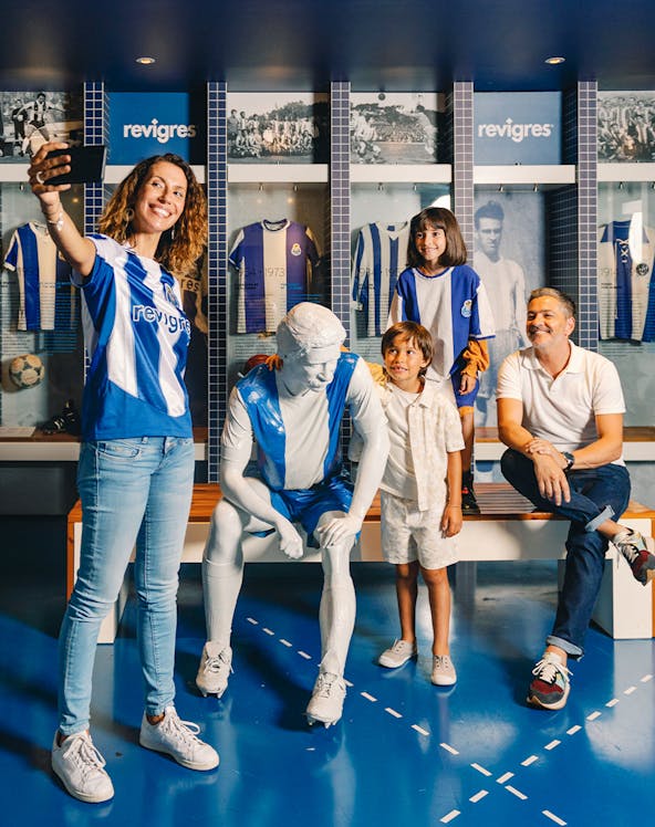 Visitors taking a selfie with a statue at FC Porto Museum, Porto, Portugal.