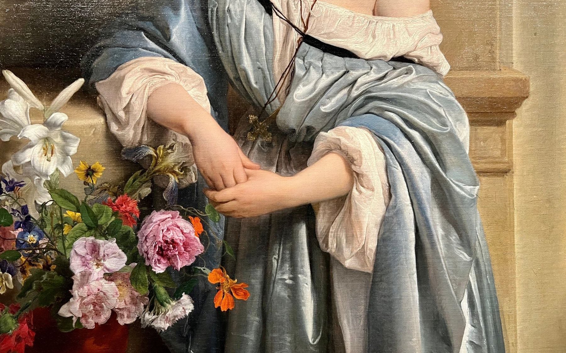 Woman in blue robe holding hands near flowers, Pinacoteca di Brera.