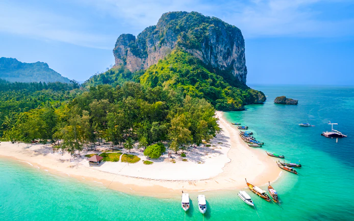 Aerial view of Ko Poda Island with sandy beach and boats in turquoise water, Thailand.