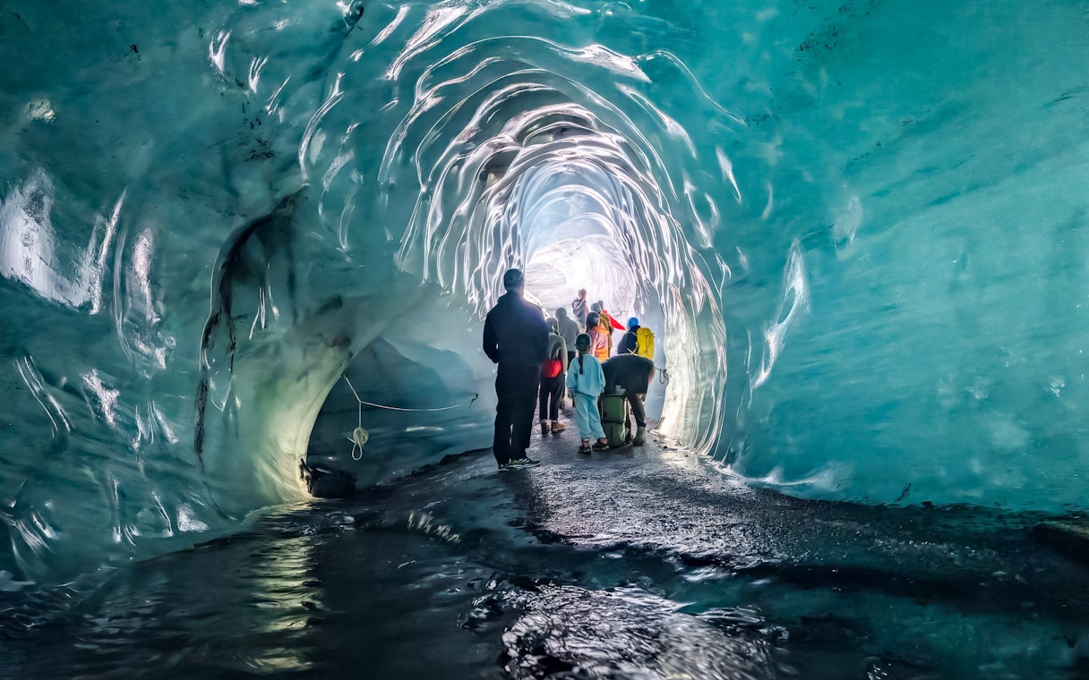 Visitors exploring the icy interior of Katla Ice Cave, Iceland.