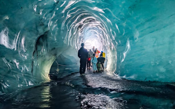 Visitors exploring the icy interior of Katla Ice Cave, Iceland.