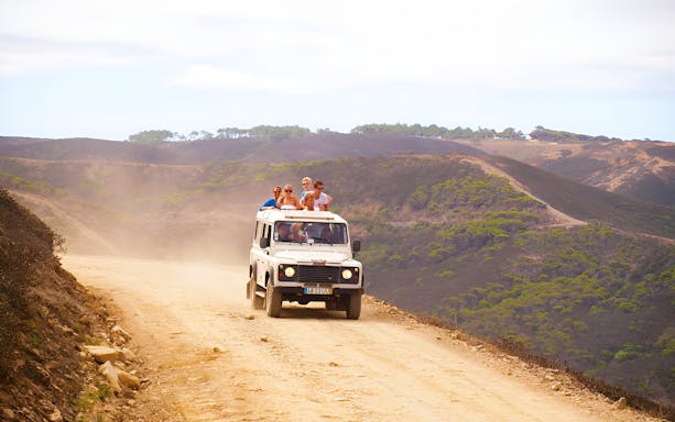 Off-road vehicle with tourists on Vicentina Coast & Southwest Alentejo Natural Park tour.