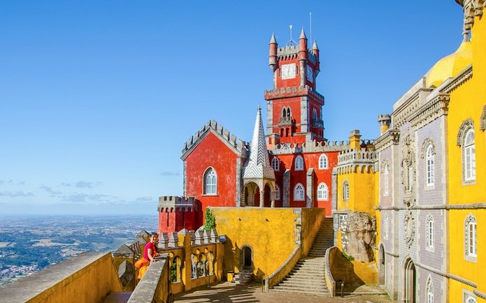 Pena Palace in Sintra with colorful towers and panoramic view of the landscape.