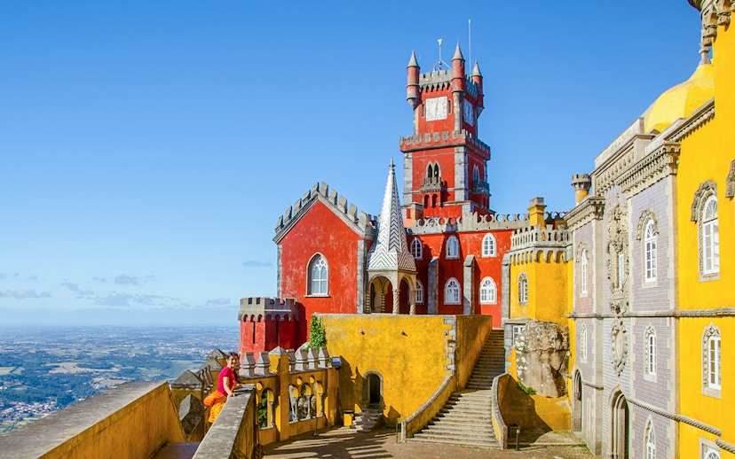 Pena Palace in Sintra with colorful towers and panoramic view of the landscape.