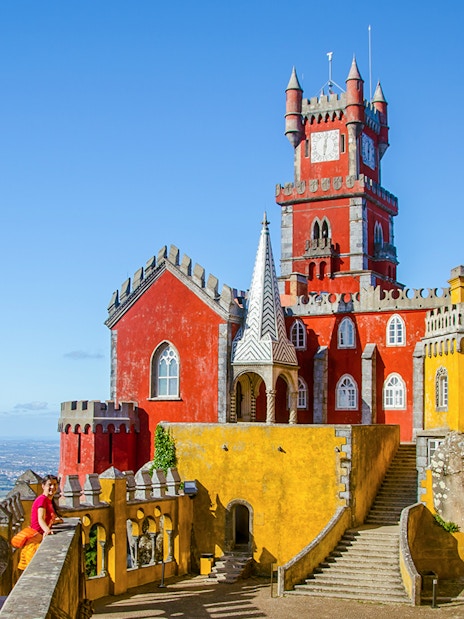 Pena Palace in Sintra with colorful towers and panoramic view of the landscape.