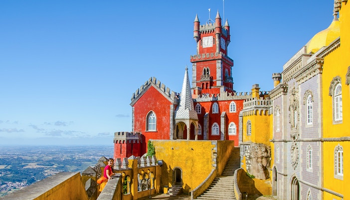 Pena Palace in Sintra with colorful towers and panoramic view of the landscape.