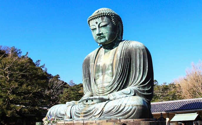 Great Buddha of Kamakura statue in Japan surrounded by trees.
