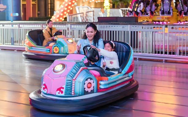 Family enjoying bumper cars at Genting Skytropolis Indoor Theme Park.