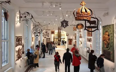 Carnavalet Museum visitors exploring historical exhibits in Paris gallery.