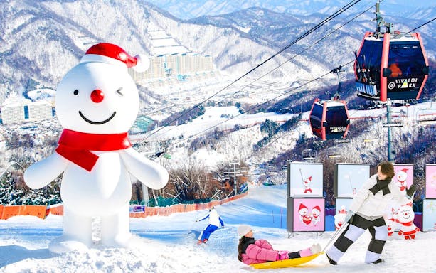 Snowman and ski lift at Vivaldi Park Ski Resort with sledding and skiing activities.
