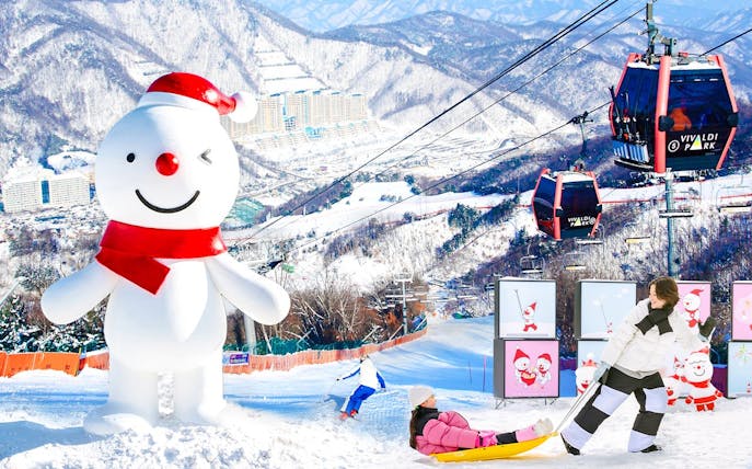 Snowman and ski lift at Vivaldi Park Ski Resort with sledding and skiing activities.