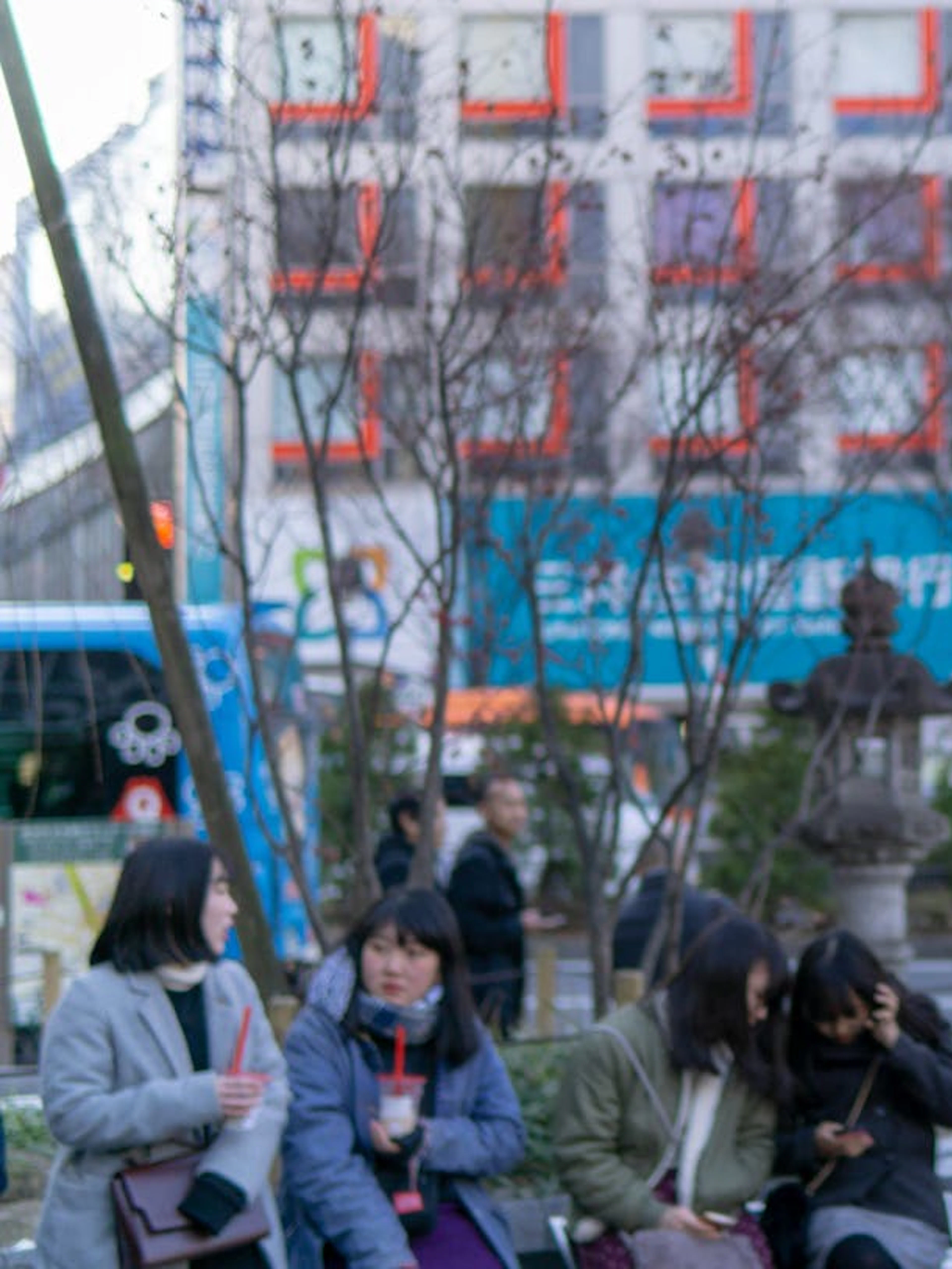Hachiko statue in Shibuya, Tokyo, with people and cityscape in the background.