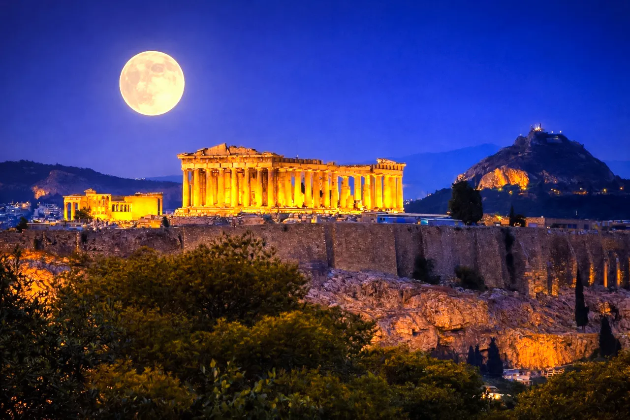 Acropolis illuminated at night with full moon, Athens walking tour.