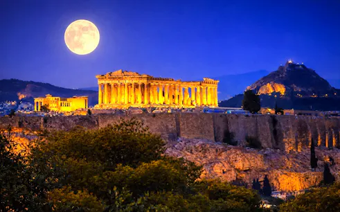 Acropolis illuminated at night with full moon, Athens walking tour.