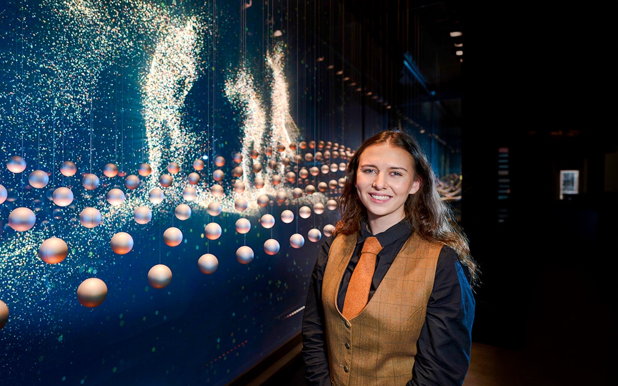 Guide at the Scotch Whisky Experience tour with interactive display in background.