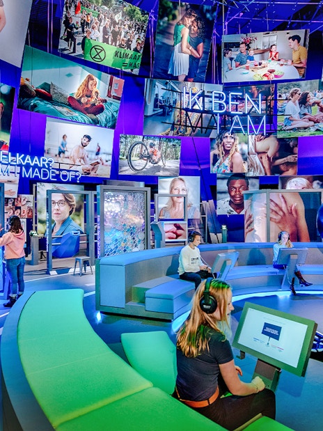 Visitors engaging with interactive human biology exhibit, using digital screens and models.