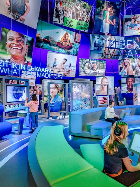Visitors engaging with interactive human biology exhibit, using digital screens and models.