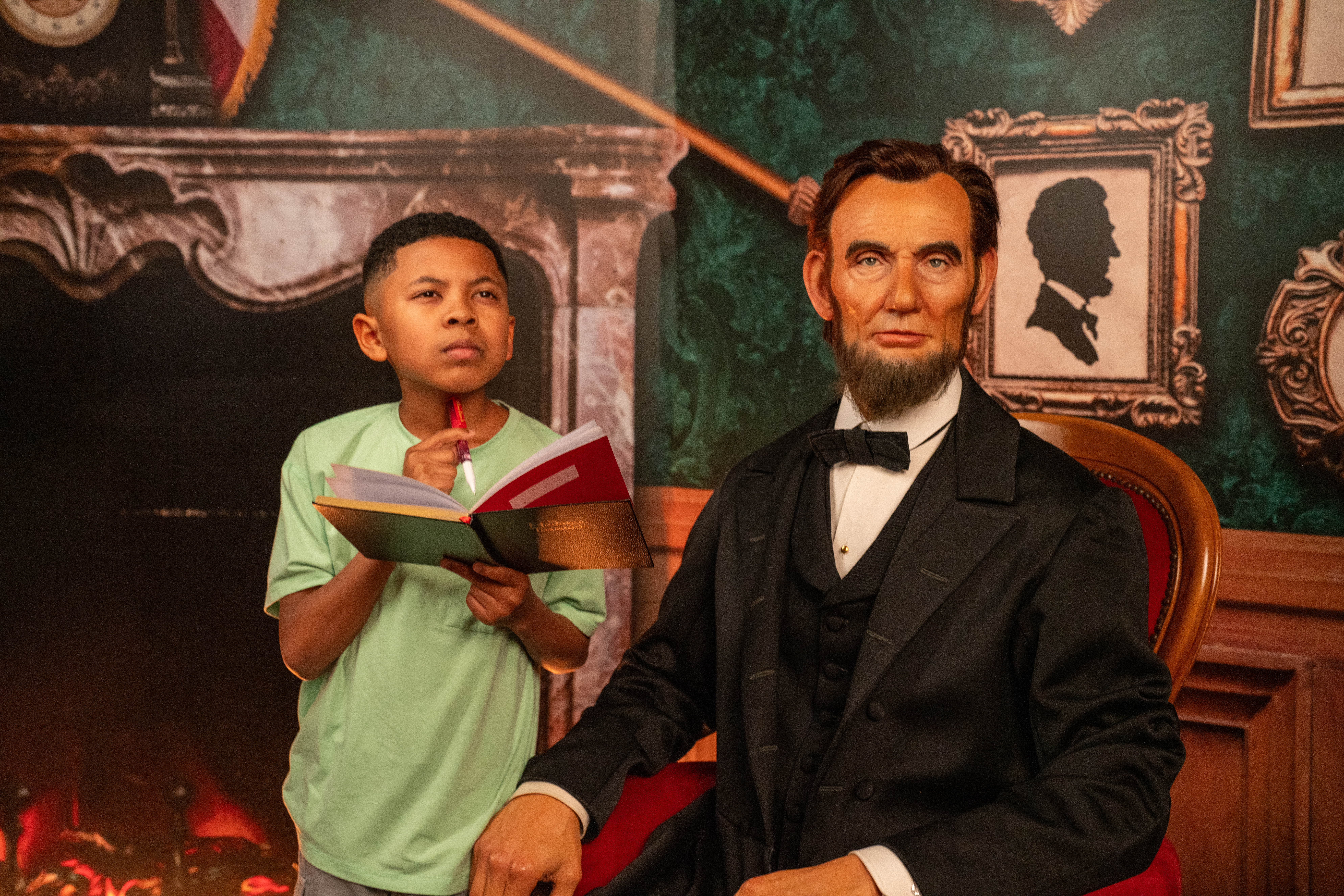 Child with notebook next to Abraham Lincoln wax figure at Madame Tussauds Orlando.