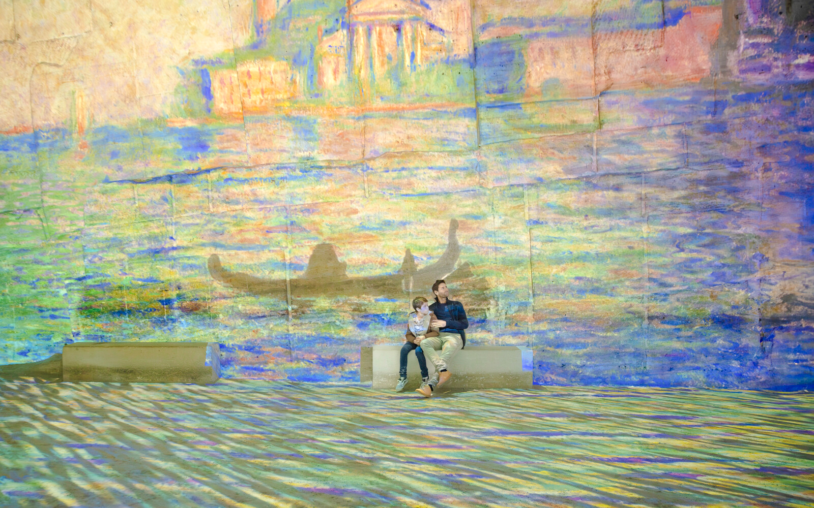 Visitors enjoying Monet projections at Carrières des Lumières, France.