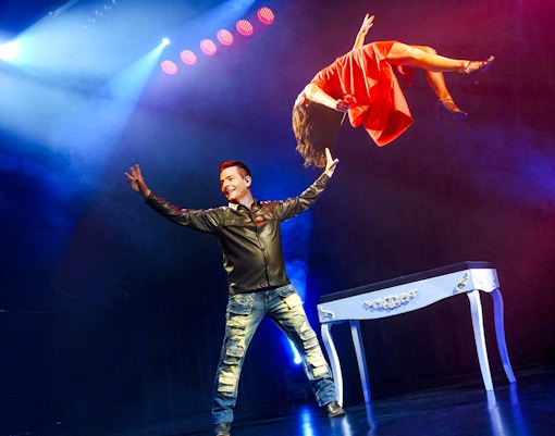 Magician performing levitation trick at The Wild Magic Show, Greg Frewin Theatre.