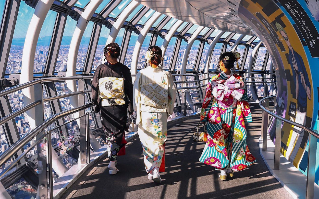 Visitors in kimonos walking inside Tokyo Skytree observation deck.