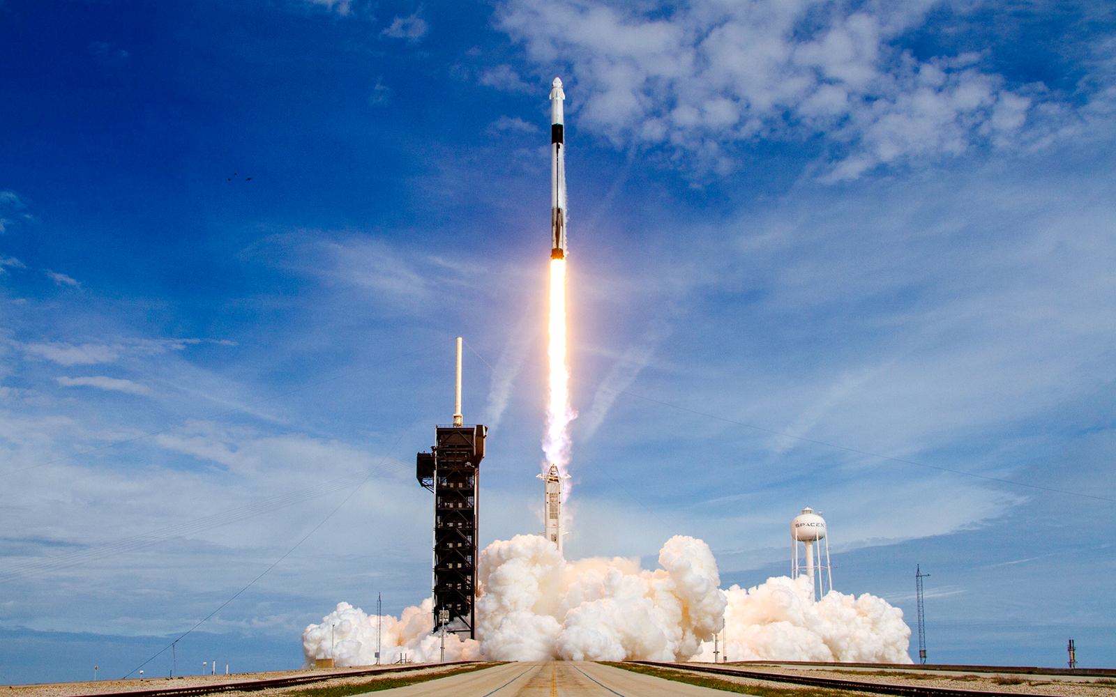 SpaceX Falcon 9 rocket launching at Cape Canaveral, Florida, with fiery exhaust trail.