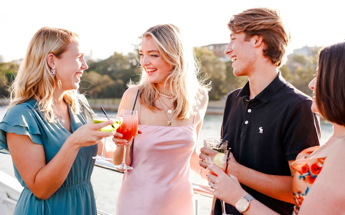 Guests enjoying drinks on a Sydney dinner cruise with live music.