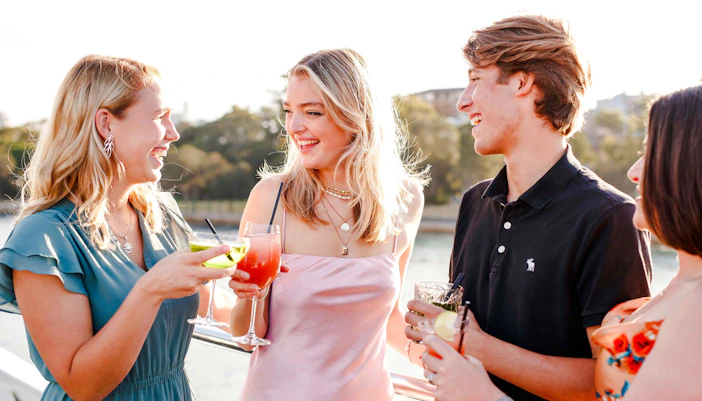 Guests enjoying drinks on a Sydney dinner cruise with live music.