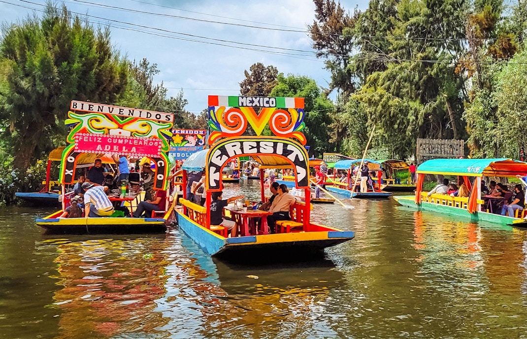 Colorful trajineras on Xochimilco canals, Mexico City, during a vibrant boat tour.
