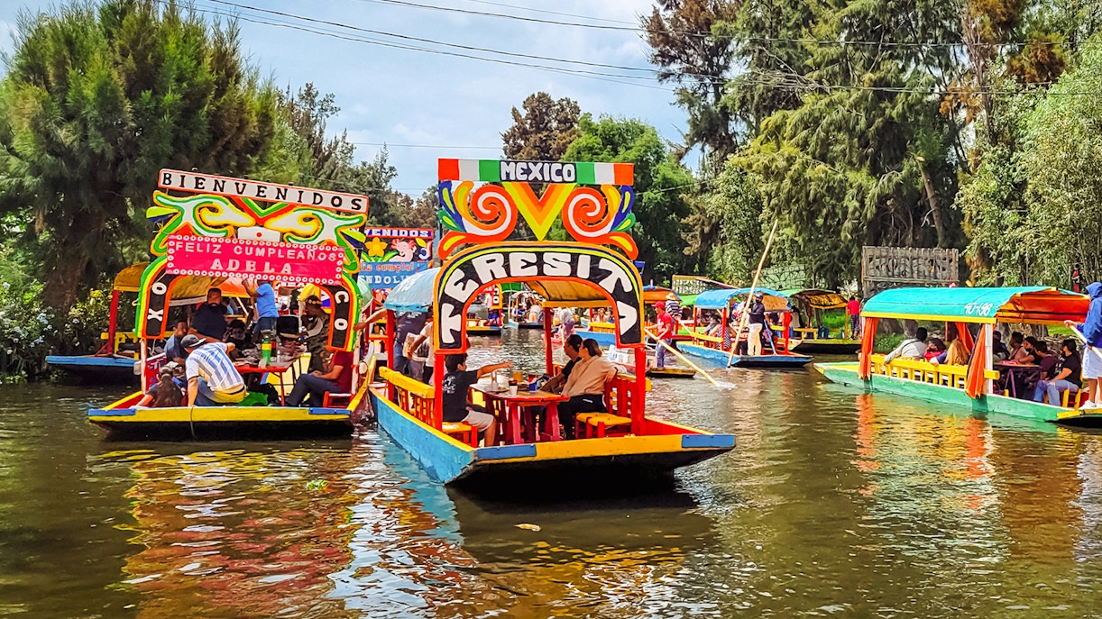 Colorful trajineras on Xochimilco canals, Mexico City, during a vibrant boat tour.