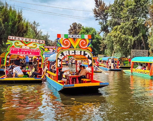 Colorful trajineras on Xochimilco canals, Mexico City, during a vibrant boat tour.