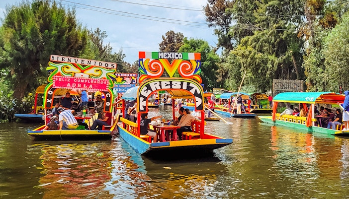 Colorful trajineras on Xochimilco canals, Mexico City, during a vibrant boat tour.