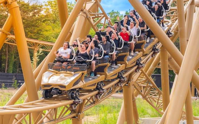 Roller coaster riders enjoying a thrilling descent at Thorpe Park.