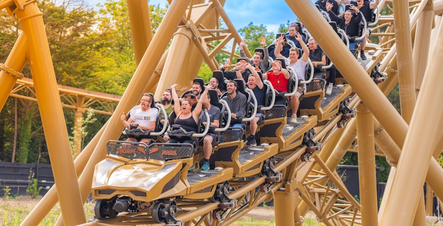Roller coaster riders enjoying a thrilling descent at Thorpe Park.